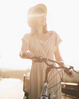 Young woman against nature background with bike