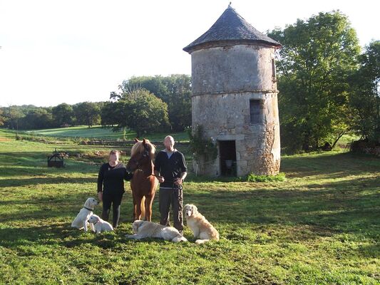 les hôtes avec leur poney et les chiens devant le pigeonnier