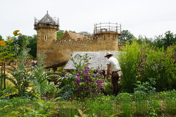 Guedelon, le jardinier avec la courtine ouest en arrière plan