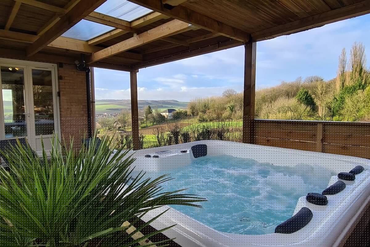 Jacuzzi sous pergola avec panorama sur la vallée de la Hem